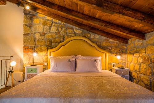 a bedroom with a large bed in a stone wall at Mediterraneo Luxury Suites Halkidiki in Vourvourou