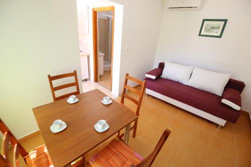 ein Wohnzimmer mit einem Tisch und einem Sofa in der Unterkunft Holiday Home Zemljak in Sukošan