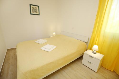 ein Schlafzimmer mit einem Bett mit zwei Handtüchern darauf in der Unterkunft Holiday Home Zemljak in Sukošan