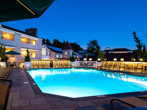 a swimming pool at night with tables and chairs at Meadowmere Resort in Ogunquit