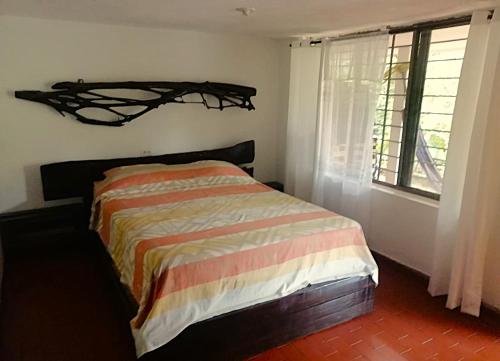 a bedroom with a bed with a branch on the wall at Casa Yantra La Lola in Pance