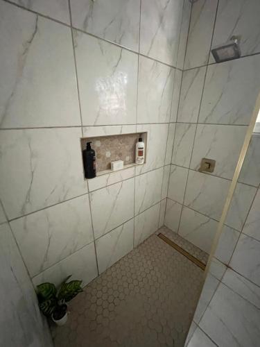 a bathroom with a shower with white tiles at New ! Casa de Campo del Río Planta in Arecibo
