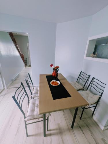 a dining room table with chairs and a plate of food on it at 203 Quadruple Bed & Breakfast bedroom Downtown in Glace Bay