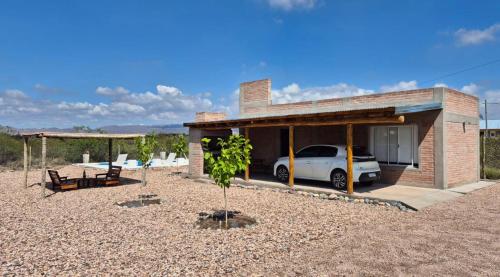 a small house with a car parked in front of it at Cabañas Jugueze San Rafael in San Rafael