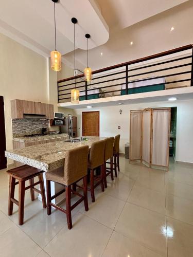a large kitchen with a large island with chairs at Loft Yol-Kin Bacalar in Bacalar