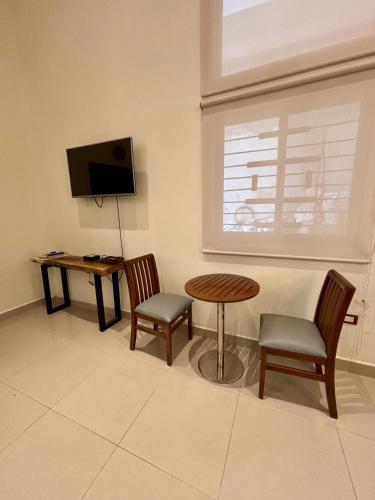 a living room with a table and chairs and a television at Loft Yol-Kin Bacalar in Bacalar