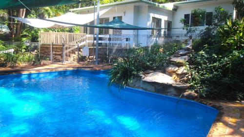 a swimming pool in front of a house at Del Haven Holiday House in Arcadia