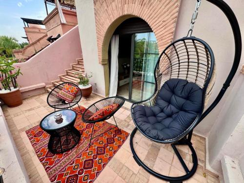 un patio con un columpio y una mesa en Golden Palms Marrakech, en Marrakech