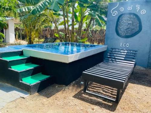 a swimming pool with a bench next to a building at Gimanhala Eco Resort in Vannativillu