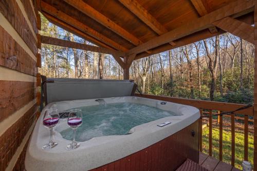 two glasses of wine in a hot tub on a deck at Hidden Hideaway in Cosby