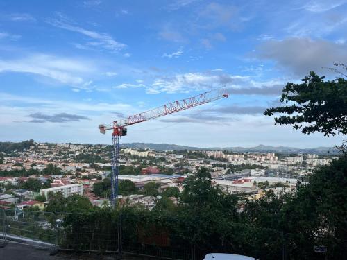 a crane on top of a city with buildings at L'appart' Toloman - Cozy et Spacieux à FDF in Fort-de-France