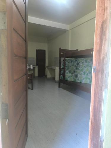an empty room with a bed and a table at The Stopover at Bangui Windmills in Bangui