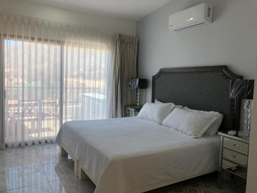 a bedroom with a bed and a large window at The Residences by Morgan in Cabo San Lucas