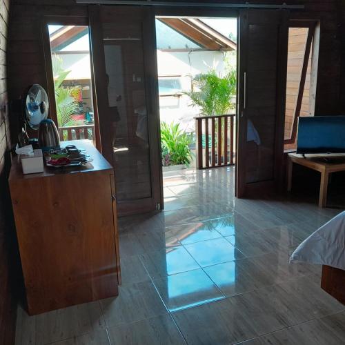 a room with an open door to a patio at Pebble Beach Bungalow in Medewi Yeh Sumbul, Bali in Jembrana