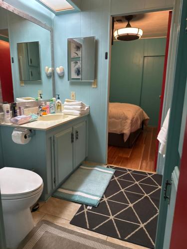 a bathroom with a sink and a toilet and a bed at Choice of comfort in Hemet
