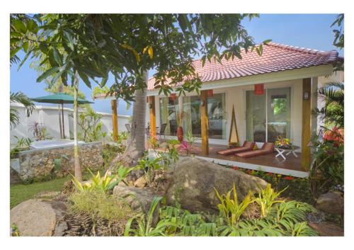 a house with a tree in front of it at Paradise Island Estate in Choeng Mon Beach