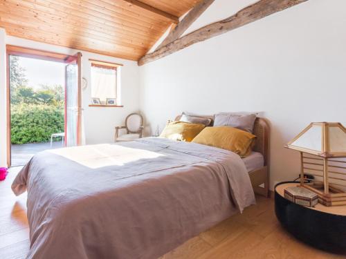 a bedroom with a bed with a wooden ceiling at Gîte familial spacieux avec piscine naturelle, proche Nantes - FR-1-306-1218 in La Limouzinière