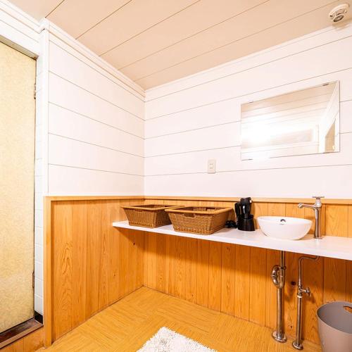 a bathroom with a sink and a counter with baskets at Hakoneyumoto Yamatokan 箱根湯本 温泉旅館 大和館 in Hakone