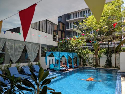 a person swimming in a pool next to a building at Home Chic Hotel in Phnom Penh