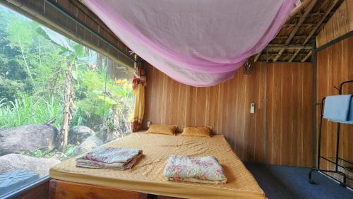 a bed in a room with a window at Dong Que Homestay-Tours-Motorbike, Car rental, Hiking in Ha Giang