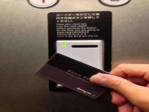 a person holding a cell phone in front of a machine at Dormy Inn Premium Namba Natural Hot Spring in Osaka