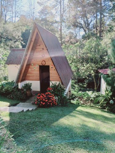 a small wooden building with a door in a yard at Samantha Hotel Campestre in Santa Cruz Verapaz