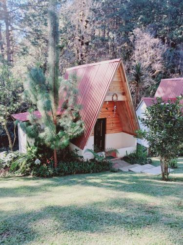 a small wooden cabin with a red roof at Samantha Hotel Campestre in Santa Cruz Verapaz
