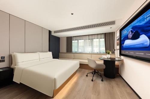 a bedroom with a white bed and a flat screen tv at Atour Hotel Shanghai Dapu Bridge ASE Center in Shanghai