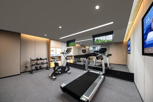 a gym with treadmills ellipticals and a flat screen tv at Atour Hotel Shanghai Dapu Bridge ASE Center in Shanghai