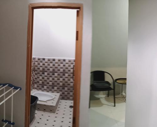 a bathroom with a toilet and a chair at 3Z Guest House in Palu
