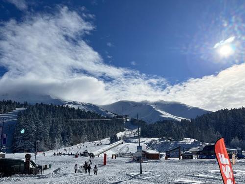 un groupe de personnes sur une piste de ski enneigée dans l'établissement Studio central au Lioran avec terrasse et parking - FR-1-787-125, à Laveissière