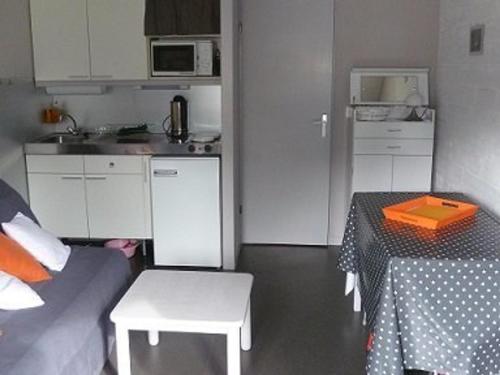 une petite cuisine avec une table, une table et un canapé dans l'établissement Charmant T2 avec balcon au cœur de la station - FR-1-787-126, à Laveissière