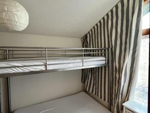Cette chambre avec lits superposés se trouve à côté d'une fenêtre. dans l'établissement Charmant T2 avec balcon au cœur de la station - FR-1-787-126, à Laveissière