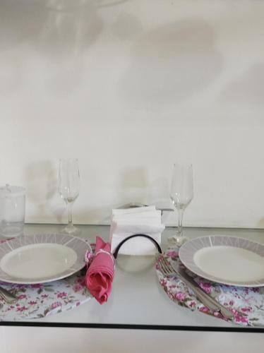 a table with two plates and glasses and a napkin at Casa Florescer in Salvador