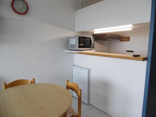 une petite cuisine avec une table et un micro-ondes dans l'établissement Studio rénové pour 4 pers avec climatisation et parking, face mer - FR-1-750-73, à Canet