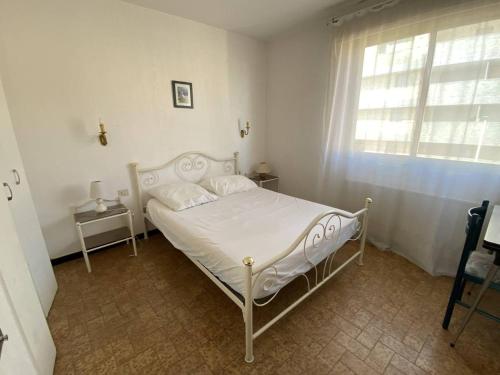 un lit blanc dans une chambre avec une fenêtre dans l'établissement Trois-pièces face mer avec parking, 6 pers - FR-1-750-75, à Canet
