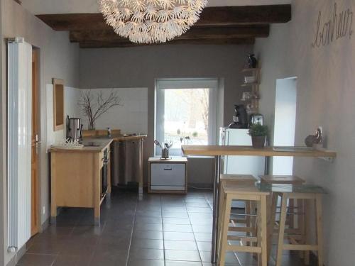 une cuisine avec une table et un lustre dans l'établissement Gîte cosy et chaleureux au bord de la Saône - FR-1-583-381, à Port-sur-Saône