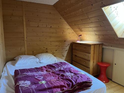 une chambre avec un lit et un mur en bois dans l'établissement Appartement duplex 6/8 pers, centre station, Le Lioran - FR-1-787-124, à Laveissière