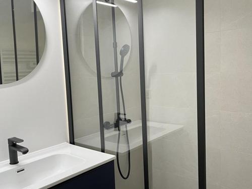 une douche avec une porte vitrée à côté d'un lavabo dans l'établissement Appartement duplex 6/8 pers, centre station, Le Lioran - FR-1-787-124, à Laveissière
