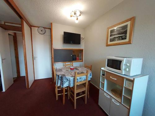 une petite cuisine avec une table et un micro-ondes dans l'établissement Studio divisible sur piste à Valmorel, proche commodités - FR-1-356-535, à Valmorel