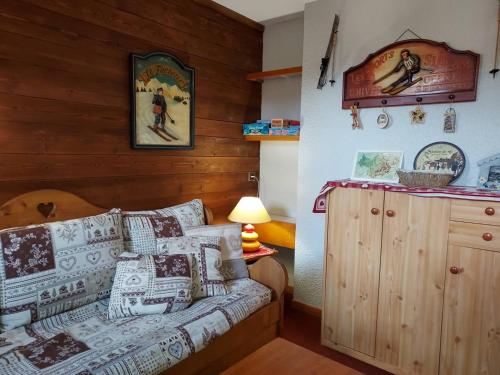 une chambre avec un lit et un mur en bois dans l'établissement Studio divisible sur piste à Valmorel, proche commodités - FR-1-356-535, à Valmorel