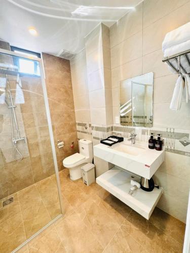 a bathroom with a toilet and a sink and a shower at SandA Villa in Phú Hiệp
