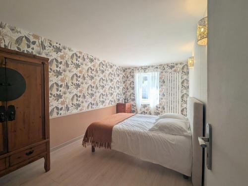 - une chambre avec un lit et du papier peint floral dans l'établissement Gîte Rural au Cœur du Berry avec Terrasse et Chevaux Bienvenus - FR-1-591-733, à Paulnay