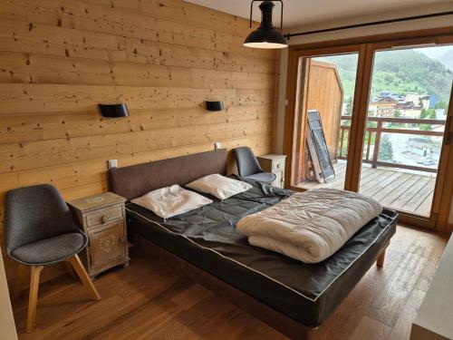 une chambre avec un lit, une chaise et une fenêtre dans l'établissement Appartement lumineux, neuf, à 250m des pistes, animaux admis - FR-1-811-14, à Les Deux Alpes