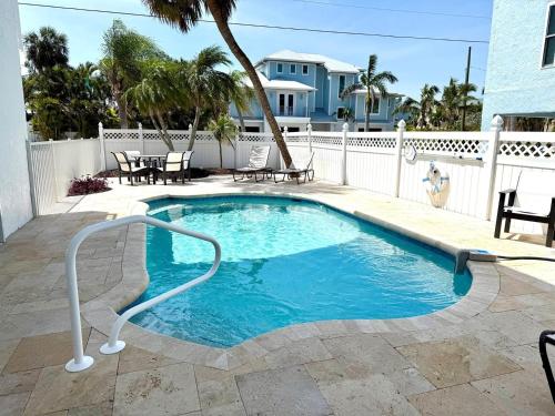 a swimming pool with a white fence at Hidden Pearl home in Holmes Beach