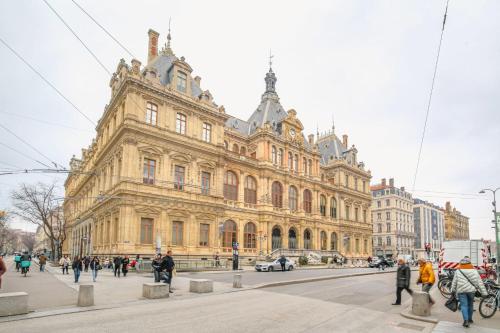 un grand bâtiment avec des gens qui marchent devant dans l'établissement Spacieux et Charmant à Cordeliers, à Lyon