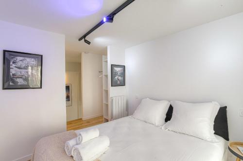 une chambre avec un lit blanc avec des oreillers blancs dans l'établissement Cosy et Chaleureux duplex Brotteaux - Masséna, à Lyon
