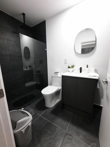 a black and white bathroom with a toilet and a sink at Nuevo y moderno loft en Bö Escalante in San José