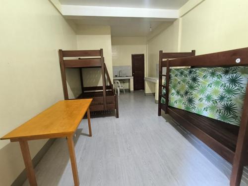 a room with two bunk beds and a desk at The Stopover at Bangui Windmills in Bangui