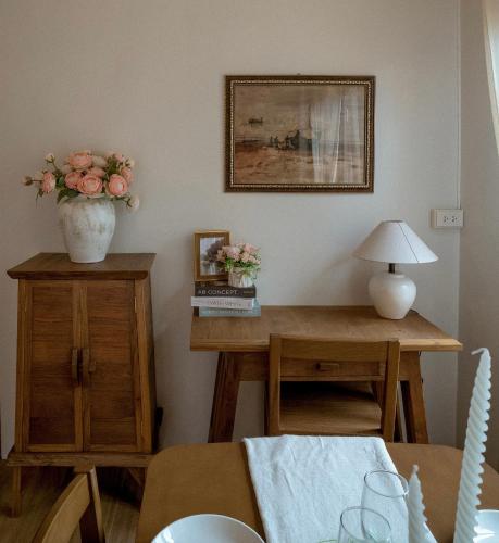 a dining room with a table with a vase of flowers on it at Gemstone Riverside, Chanthaburi in Chanthaburi